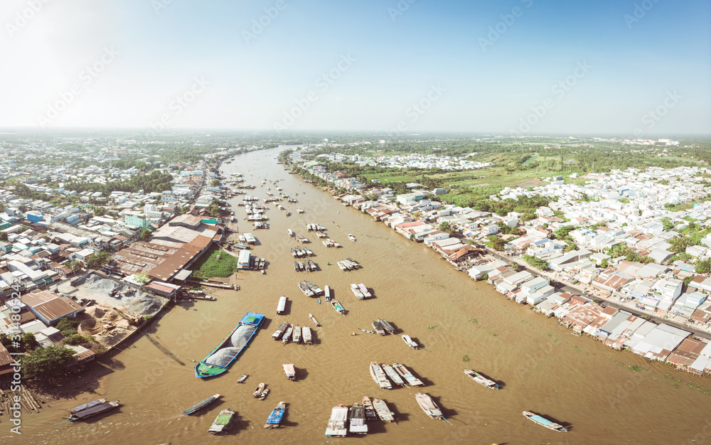 Aerial view of Cai Rang floating market at sunrise, boats selling wholesale fruits and goods on Can Tho River, Mekong Delta region, South Vietnam, tourism destination.