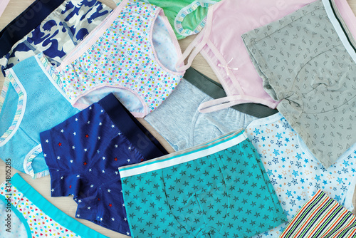 A lot of children's underwear. Underwear for children in the form of shirts and pants. Clothing for girls and boys. Background from underwear of different types. Cotton underwear. photo