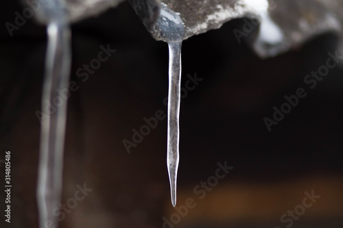 Icicles hang on the old roof. Close up © OB production