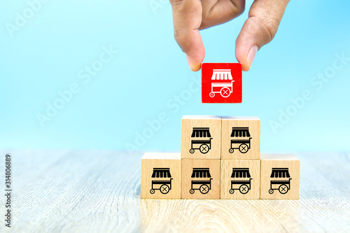 Franchise business,Businessman hand choose reg color wooden toy blog stacked with franchise marketing icons Store. photo