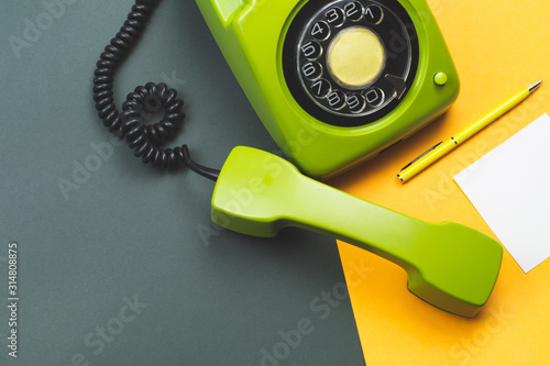 Classic phone with handset. pen with a note. office background. vintage green telephone with phone receiver. old communication technology