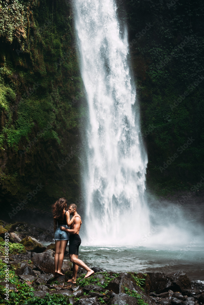 A Couple In Love On A Waterfall A Man Of Athletic Build Kisses A Beautiful Girl At The