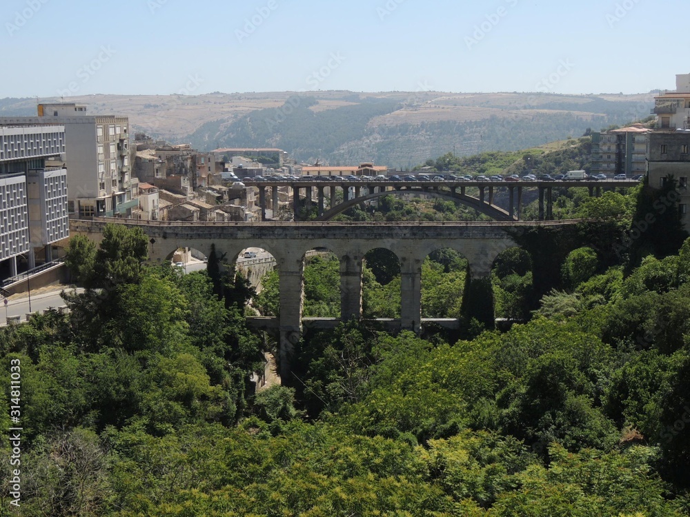 Ragusa – Panorama of the three bridges of the city over deep green canyon between the hills
