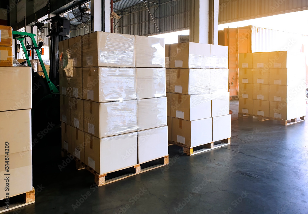 Foto de Packaging boxes stacked on wooden pallets at storage warehouse