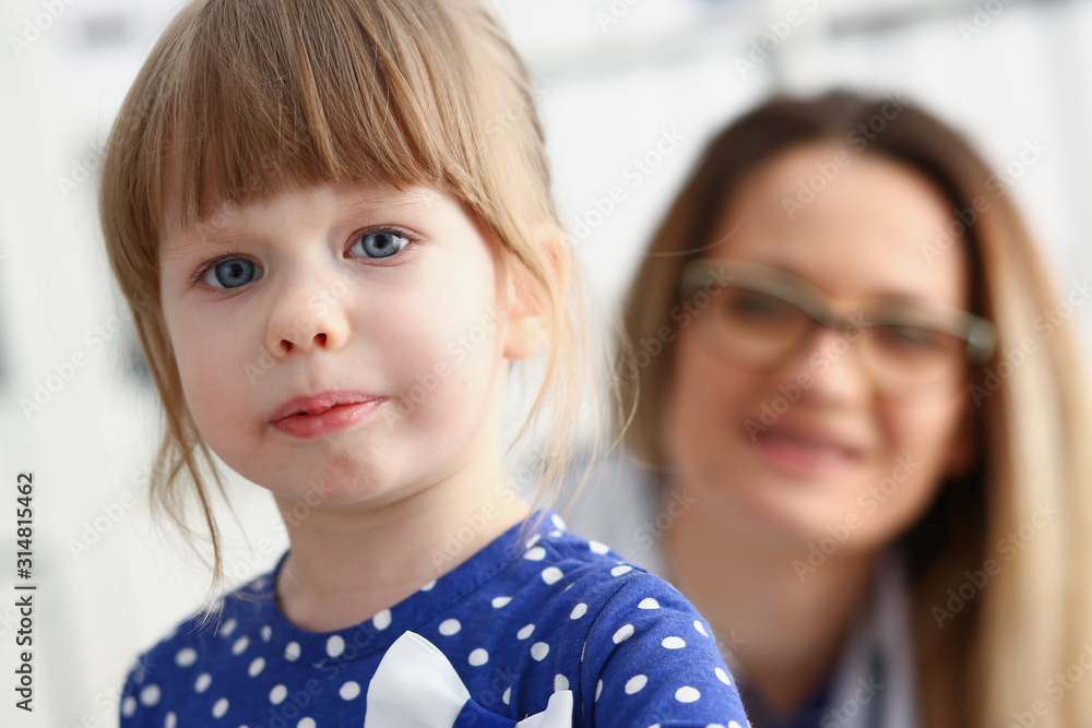 A small child is afraid in the hospital room. The doctor holds his hands and soothes the portrait. A small child is afraid in the hospital room. The doctor holds his hands and soothes the portrait.