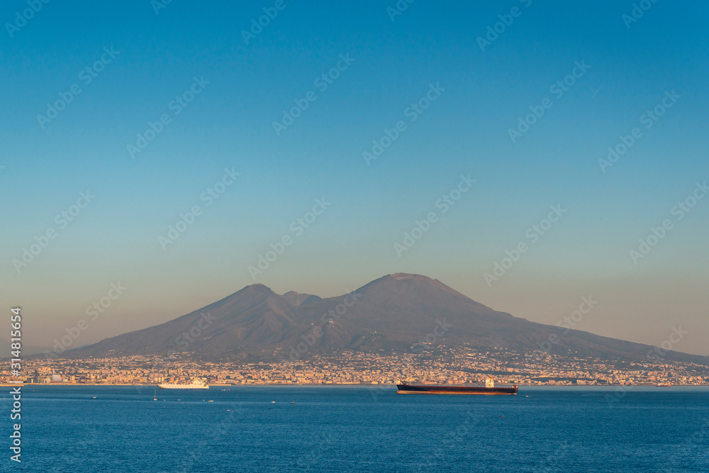 Cargo ship and Mount Vesuvius in Naples bay at the dawn (Napoli bay), Naples, Italy