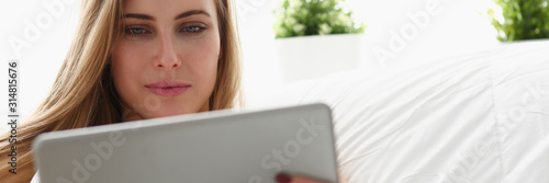 young blond beautiful woman work winh laptop stay in bed early morning