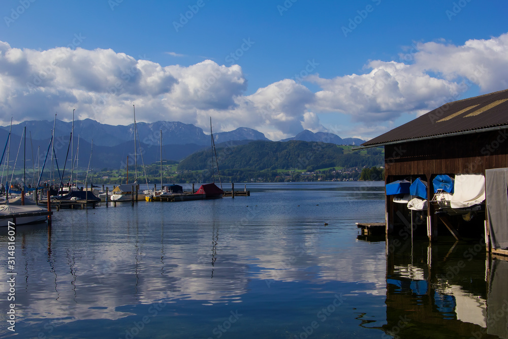 background view of a boat shed and yachts on the water on Lake Traunsee in the vicinity of Gmunden, Austria