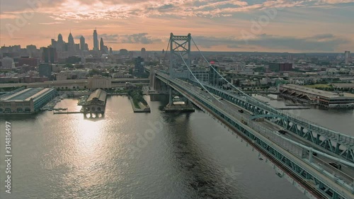 Aerial flying over the Ben Franklin Bridge and Delaware River at sunset. In the background is the city skyline. Philadelphia, USA photo