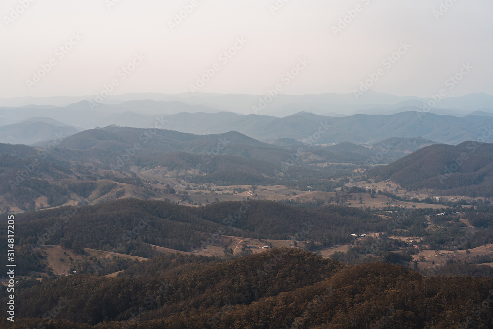 Looking down into the valley at the small town small of Byabarra, New South Wales with hazy mountains in the distance. Taken from Mount Comboyne (aka Comboyne Rock) lookout. 