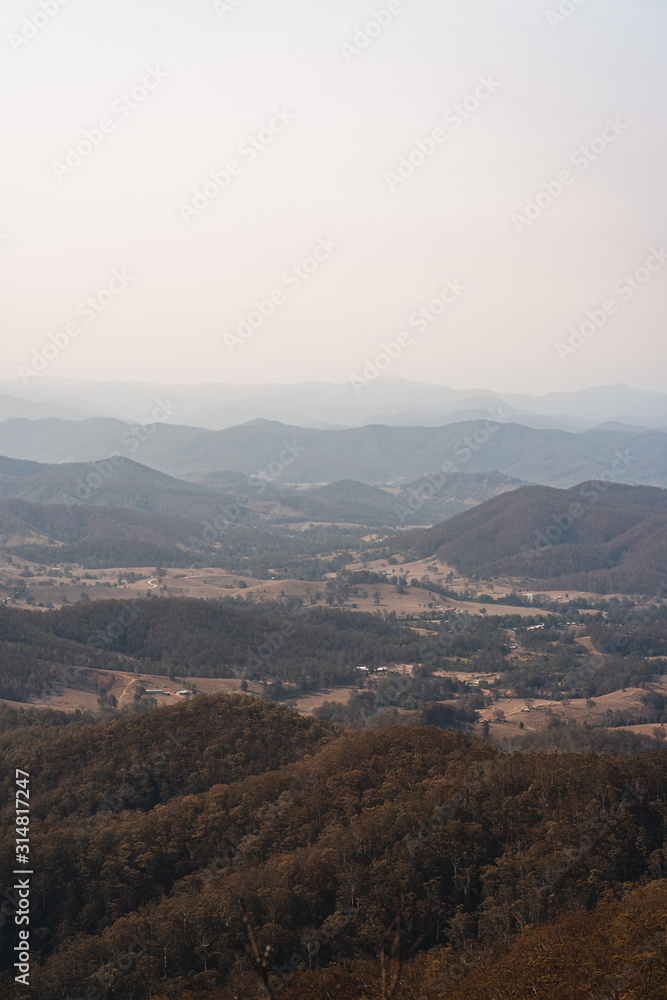 Looking down into the valley at the small town small of Byabarra, New South Wales with hazy mountains in the distance. Taken from Mount Comboyne (aka Comboyne Rock) lookout. 