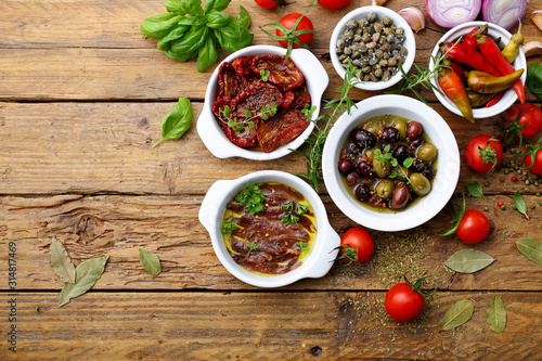 cibo mediterraneo spunti con acciughe pomodori secchi olive sfondo rustico photo