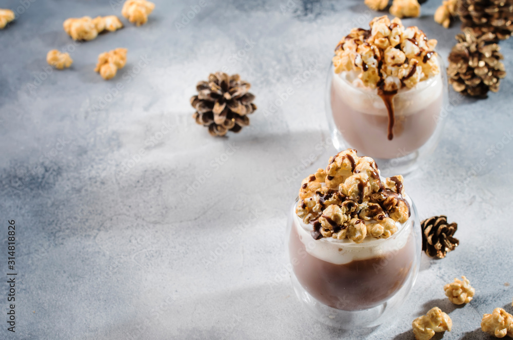 Cold chocolate dessert with whipped cream, popcorn and caramel topping in glasses on beige background, place for text Cold chocolate dessert with whipped cream, popcorn and caramel topping in glasses on beige background, place for text