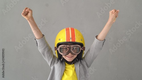 Happy child wearing racing helmet and goggles. 4K