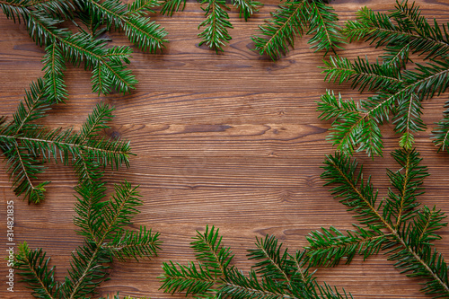 Christmas frame background. Green fluffy pine tree twigs on aged wooden table. winter holidays concept