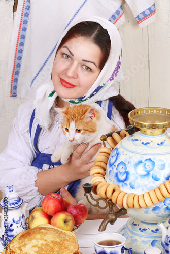 The girl holds a red cat in her arms. Maslenitsa photo