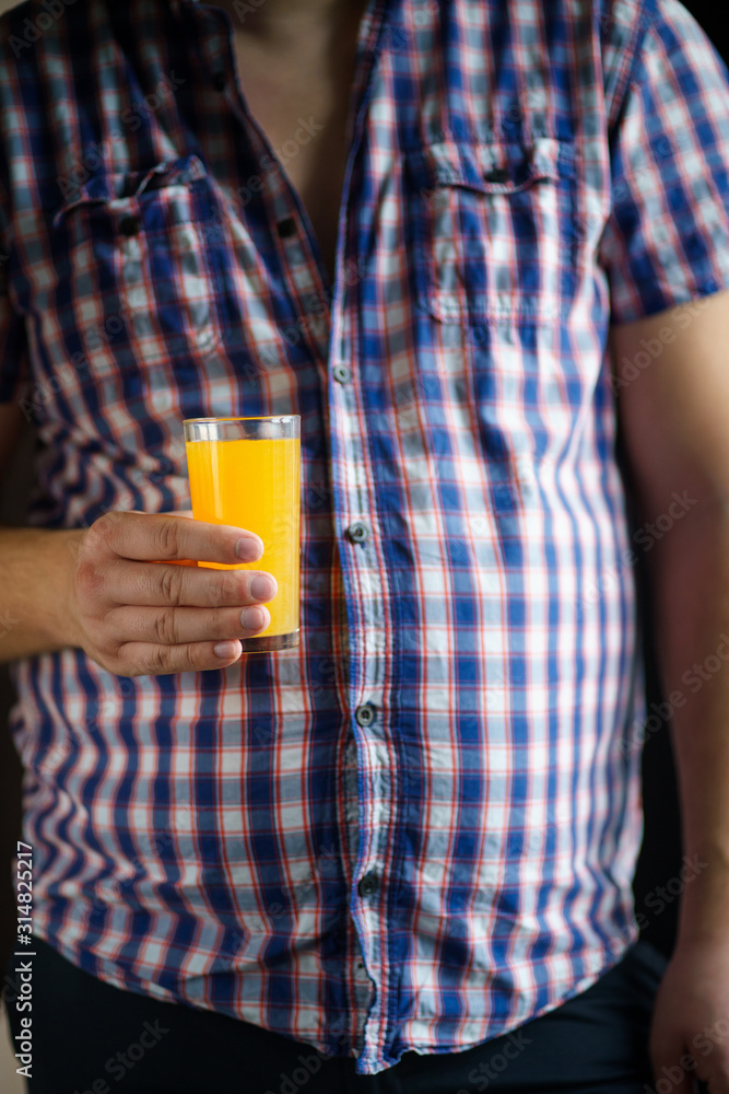 sugar contain, detox, useful and tasty drink, vitamin beverage for balanced nutrition. man drinking orange juice sugar contain, detox, useful and tasty drink, vitamin beverage for balanced nutrition. man drinking orange juice