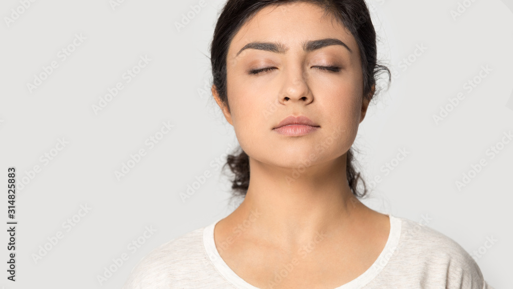 Close up head shot cropped portrait young indian girl meditating. Close up head shot cropped portrait young indian girl meditating.