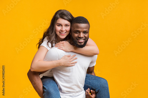 Loving black guy carrying his girlfriend on his back