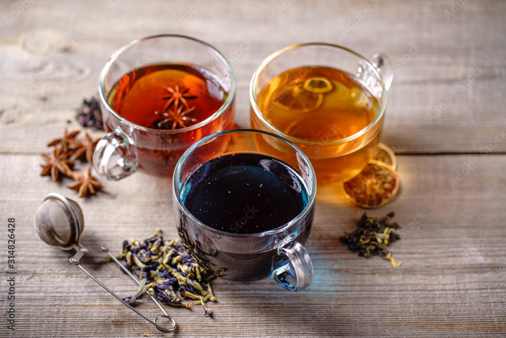 Collection of brewed green, cinnamon anise spiced and blue anchan tea in glass mugs. Tea shop and cafes Collection of brewed green, cinnamon anise spiced and blue anchan tea in glass mugs. Tea shop and cafes