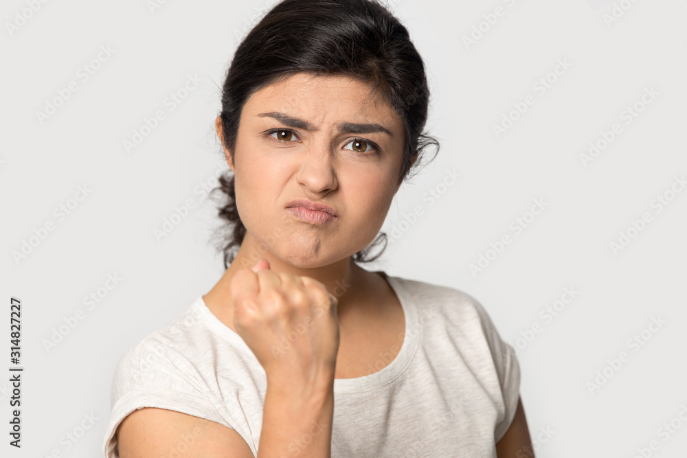Aggressive angry indian young woman clenching fist. Aggressive angry indian young woman clenching fist.