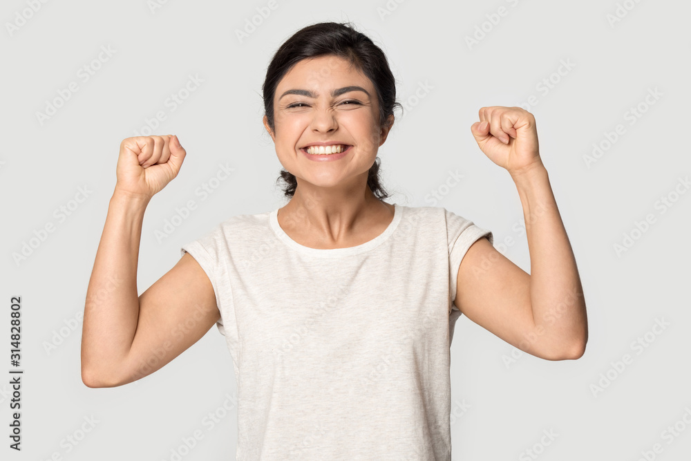 Euphoric millennial indian girl clenched fists, making yes gesture. Euphoric millennial indian girl clenched fists, making yes gesture.