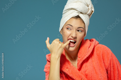 Cheerful attractive funny teen girl clean her teeth in the morning. Over blue background. photo