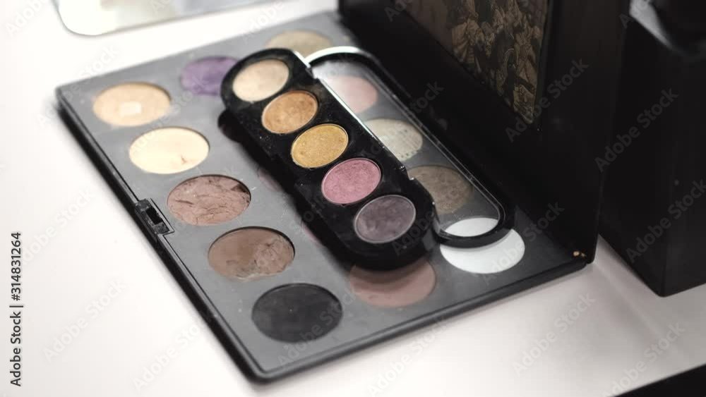 An artist has cosmetics. She decides which color to use. It is a closeup of a palette. An artist has cosmetics. She decides which color to use. It is a closeup of a palette.