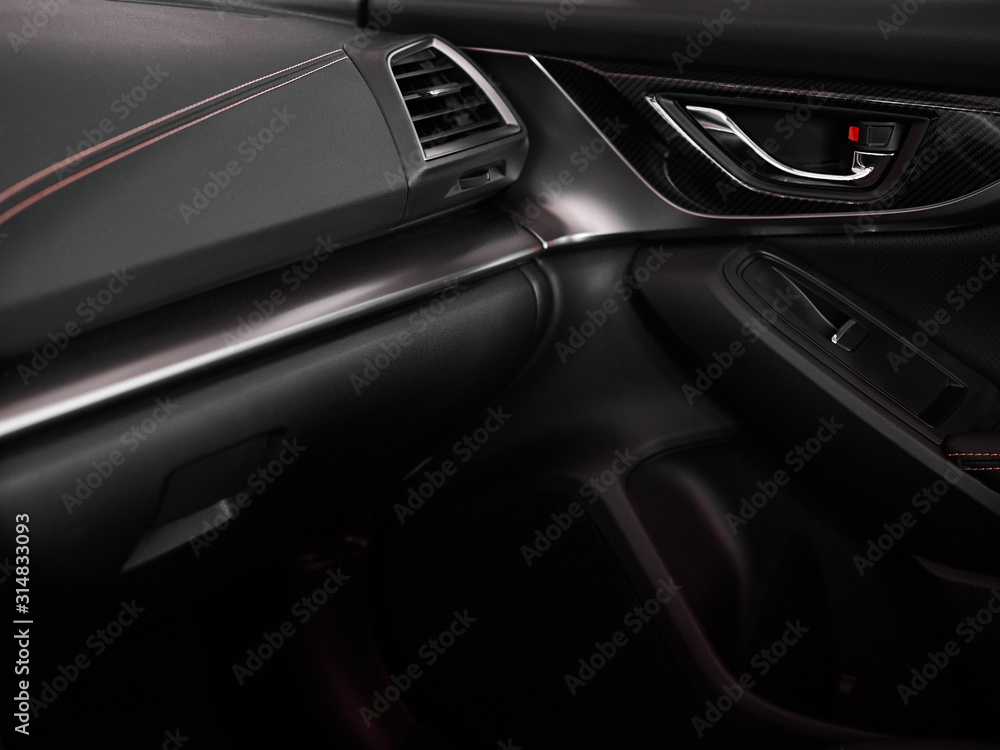 Close up door and panel black interior of modern car with red stitching