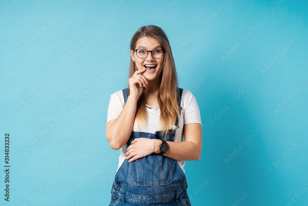 Portrait of good-looking, young, cheerful pregnant woman making a surprised face in the studio over blue background Portrait of good-looking, young, cheerful pregnant woman making a surprised face in the studio over blue background
