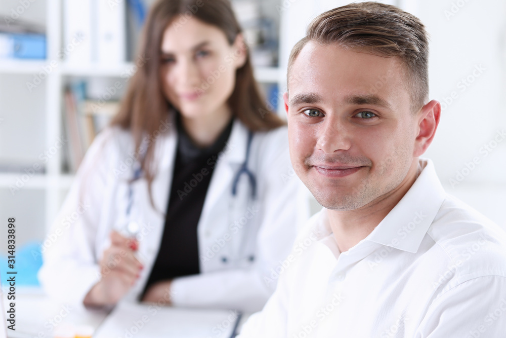 Satisfied happy handsome smiling male patient with doctor at her office. High level and quality medical service therapeutist consultation work and career physical healthy lifestyle concept Satisfied happy handsome smiling male patient with doctor at her office. High level and quality medical service therapeutist consultation work and career physical healthy lifestyle concept