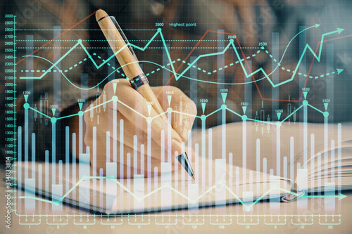 Multi exposure of woman s hands making notes with forex graph hologram. Concept of technical analysis.