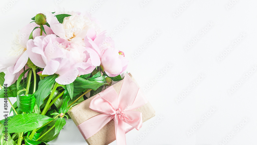 Romantic greeting card with handmade gift box and bunch of pink peonies. White background, space for text