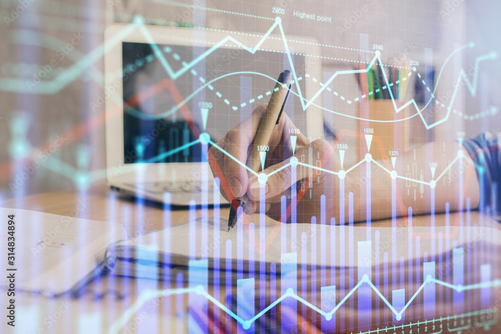 Financial forex charts displayed on woman's hand taking notes background. Concept of research. Double exposure Financial forex charts displayed on woman's hand taking notes background. Concept of research. Double exposure
