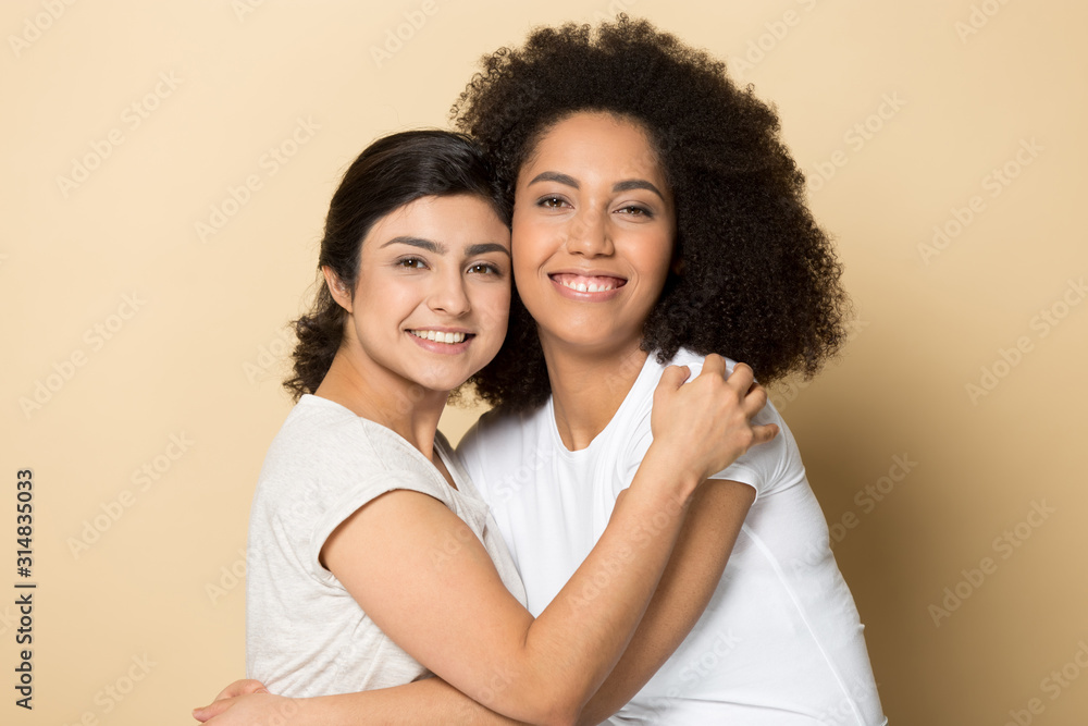 Smiling mixed race diverse young female friends embracing. Smiling mixed race diverse young female friends embracing.