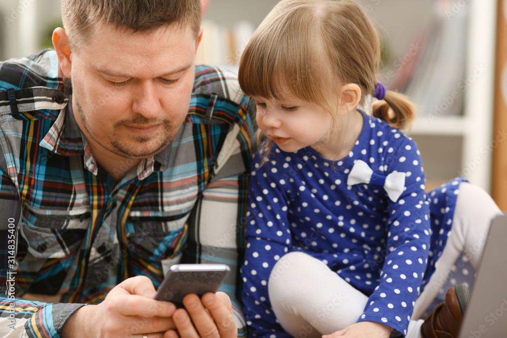 Cute little girl on floor carpet with dad use cellphone calling mom portrait. Life style apps social web network wireless ip telephony concept Cute little girl on floor carpet with dad use cellphone calling mom portrait. Life style apps social web network wireless ip telephony concept