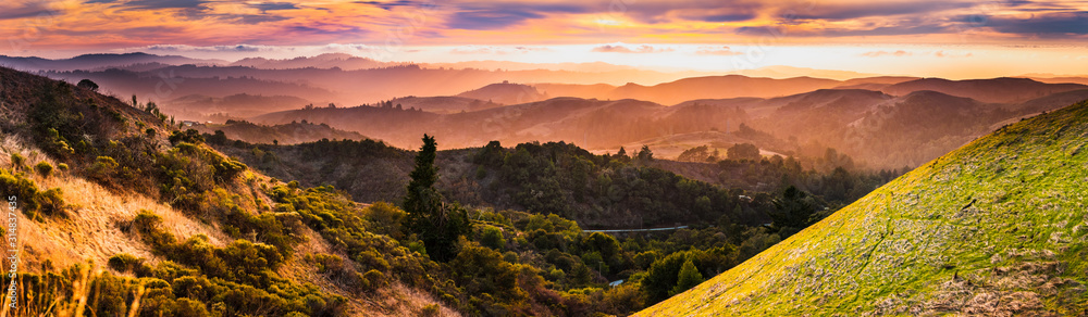 Expansive panorama in Santa Cruz mountains, with hills and valleys illuminated by the sunset light; San Francisco Bay Area, California - obrazy, fototapety, plakaty 
