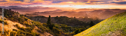 Fototapeta Expansive panorama in Santa Cruz mountains, with hills and valleys illuminated by the sunset light; San Francisco Bay Area, California
