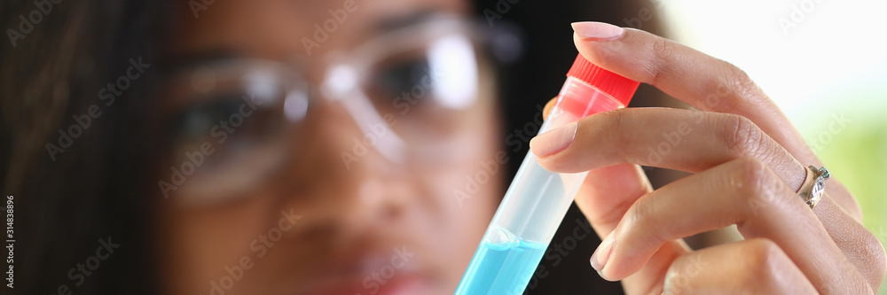 A female chemist holds test tube of glass in his hand overflows liquid solution potassium permanganate conducts an analysis reaction takes various versions reagents using chemical manufacturing. A female chemist holds test tube of glass in his hand overflows liquid solution potassium permanganate conducts an analysis reaction takes various versions reagents using chemical manufacturing.