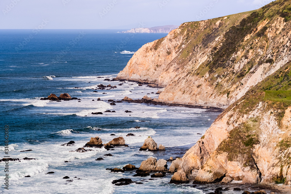 View of the dramatic Pacific Ocean coastline, with rocky cliffs, on a sunny day, Point Reyes National Seashore, California