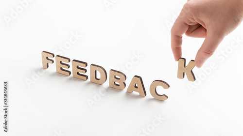 Woman creating Word feedback of wooden letters on white