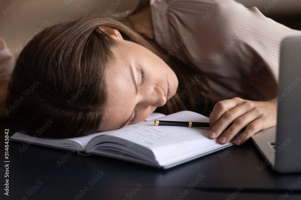 Exhausted female fall asleep working on laptop at workplace Exhausted female fall asleep working on laptop at workplace