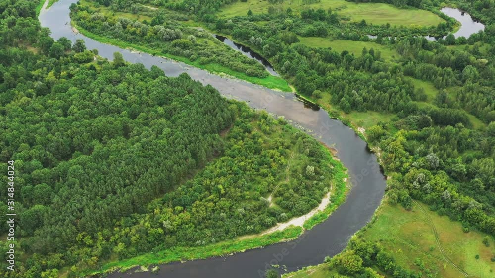 Aerial View Green Forest Woods And River Landscape In Summer Day. Top View Of Beautiful European Nature From High Attitude In Autumn Season. Drone View. Bird's Eye View Aerial View Green Forest Woods And River Landscape In Summer Day. Top View Of Beautiful European Nature From High Attitude In Autumn Season. Drone View. Bird's Eye View