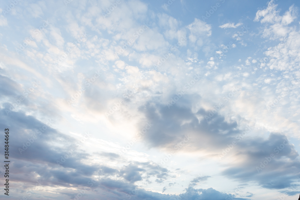 Sunrise, blue sky with a pastel colored. Soft texture of fluffy clouds. Concept for airy light dreams and travel.