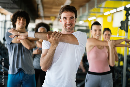 Group of happy multiracial friends exercising together in gym