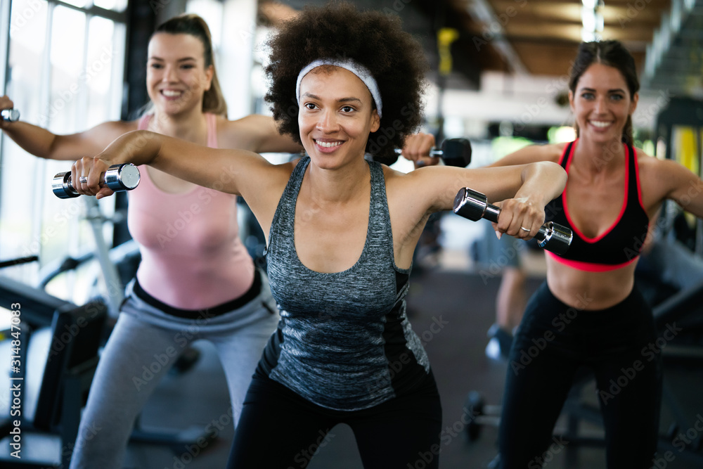 Beautiful fit people exercising together in gym Beautiful fit people exercising together in gym