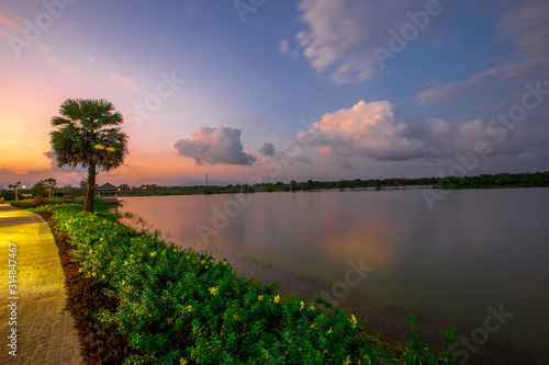 The blurred abstract background of the colorful twilight evening sky near the large lake, with cool breezes while sitting or exercising in the park.
