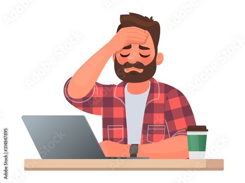Tired man at the desktop. Headache or illness at work. Overwork and difficulties of an office worker