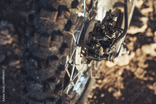 Close-up of disc rear brakes of off-road motorcycle enduro  dirty wheel