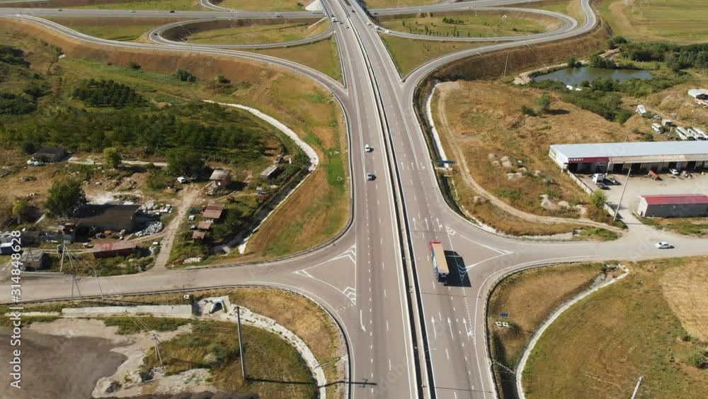 Aerial view. On freeway, road junction, cars are driving fast. Summer, day. Aerial view. On freeway, road junction, cars are driving fast. Summer, day.